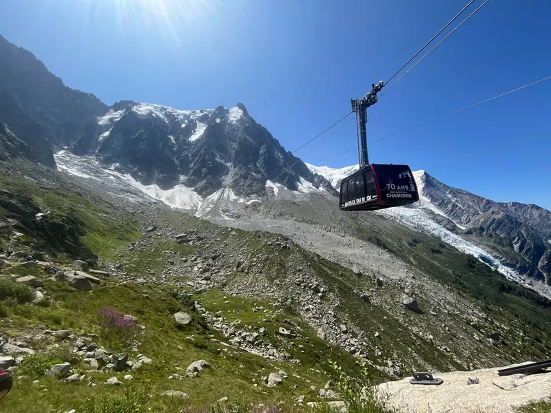 Cabine du téléphérique de l’Aiguille du Midi au-dessus des moraines, les glaciers du Mont-Blanc en fond